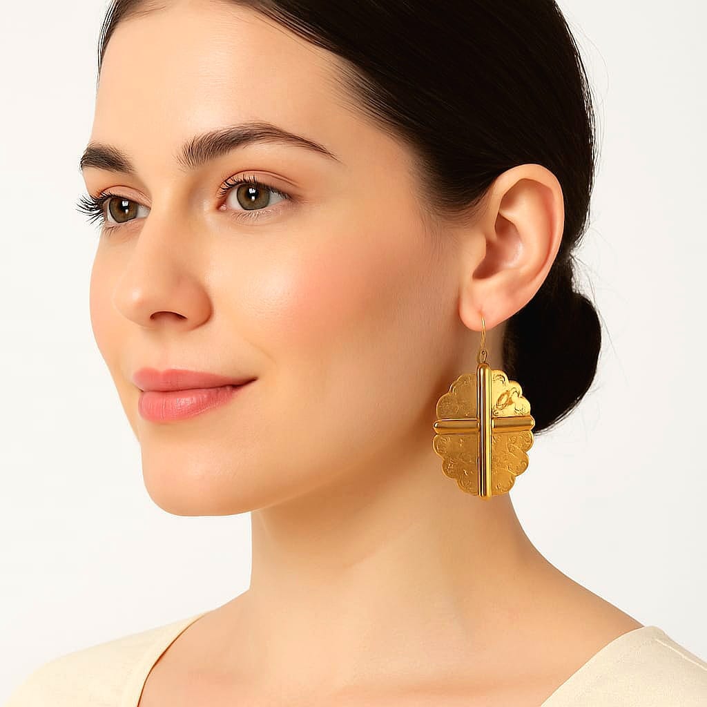 Woman wearing gold earrings on a plain background